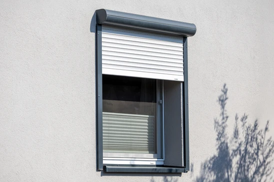 Intérieur résidentiel avec stores vénitiens blancs installés sur fenêtres
