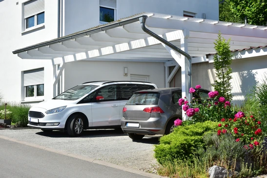 Extérieur résidentiel avec carport moderne à structure métallique blanche et couverture polycarbonate translucide
